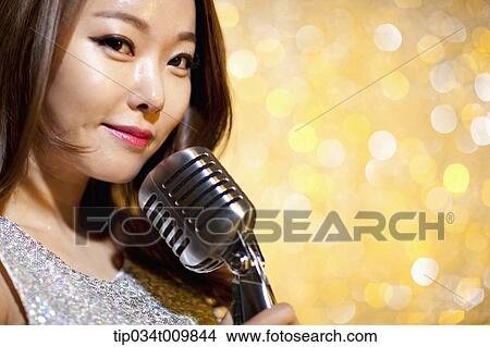 close up of a woman singing with microphone in fancy dress View Large Photo Image Picture - close up of a woman singing with microphone in fancy dress. Fotosearch