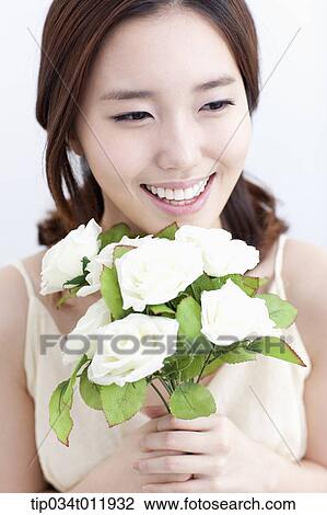 Stock Image - close up shot of a lady holding a bundle of flowers. Fotosearch