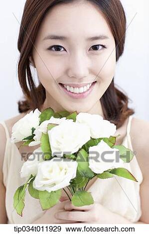Stock Photo - close up shot of a lady holding a bundle of flowers. Fotosearch
