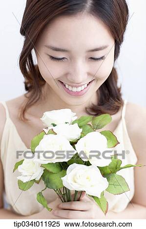 Stock Photography - close up shot of a lady holding a bundle of flowers. Fotosearch