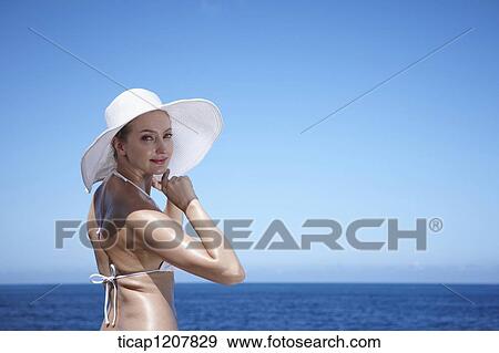 Stock Photo - close up shot of a lady in bikini and beach hat. Fotosearch