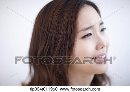 Stock Image - close up shot of a lady smiling while crying. Fotosearch
