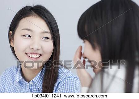Stock Image - close up shot of a lady talking to her friend. Fotosearch