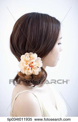Stock Photography - close up shot of a lady with a flower pin on the hair. Fotosearch