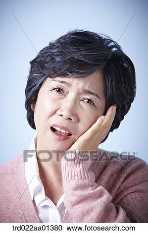 Stock Image - close up shot of a middle aged woman frowning. Fotosearch