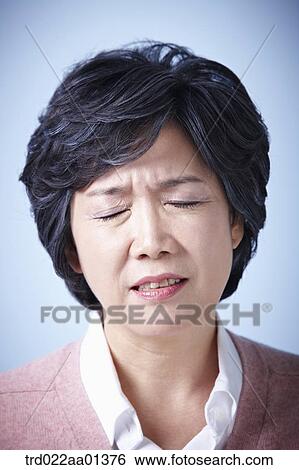 Stock Photograph - close up shot of a middle aged woman frowning. Fotosearch