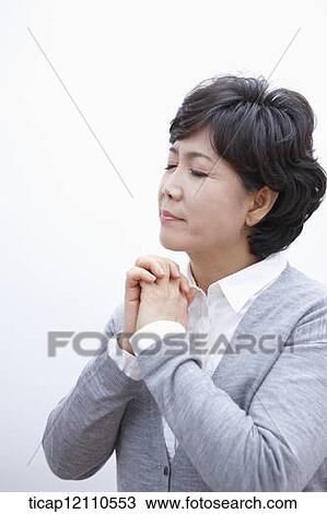 Stock Image - close up shot of a mother praying. Fotosearch