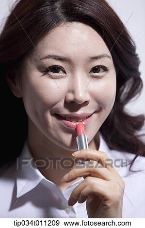Stock Photo - close up shot of a woman putting lipstick on. Fotosearch