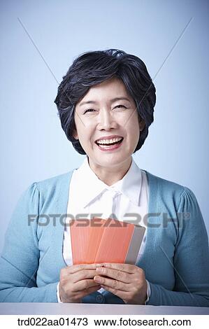 Stock Image - close up shot of happy middle aged woman with bankbooks. Fotosearch