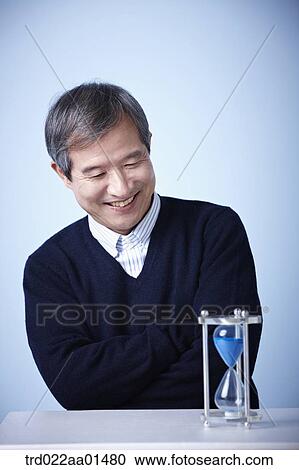 close up shot of middle aged man with sand hourglass View Large Photo Image Stock Image - close up shot of middle aged man with sand hourglass. Fotosearch