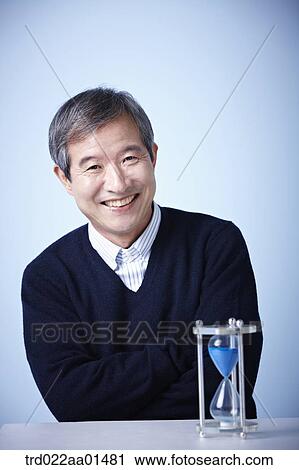 close up shot of middle aged man with sand hourglass View Large Photo Image Stock Image - close up shot of middle aged man with sand hourglass. Fotosearch