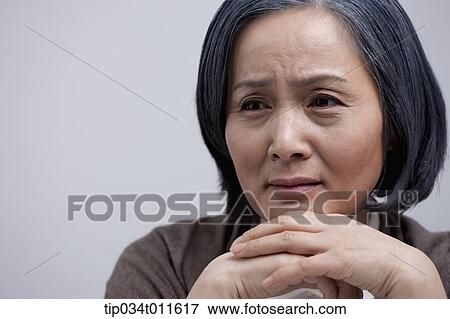 Stock Photo - close up shot of middle aged woman looking sad. Fotosearch