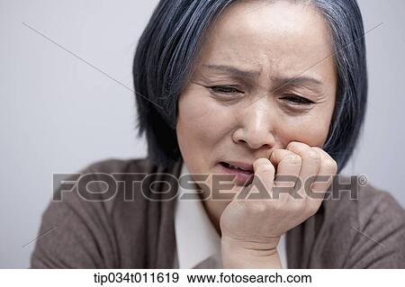 Stock Photo - close up shot of middle aged woman looking sad. Fotosearch