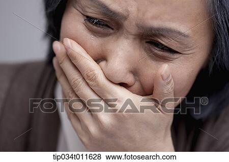 Stock Photo - close up shot of middle aged woman crying. Fotosearch