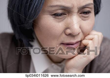 Stock Photograph - close up shot of middle aged woman crying. Fotosearch
