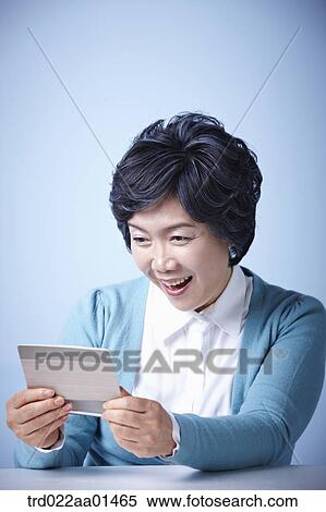 close up shot of middle aged woman happily opening bankbook View Large Photo Image Stock Photography - close up shot of middle aged woman happily opening bankbook. Fotosearch