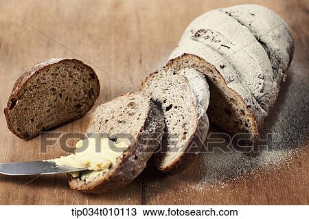 Stock Image - cut bread with butter on table. Fotosearch