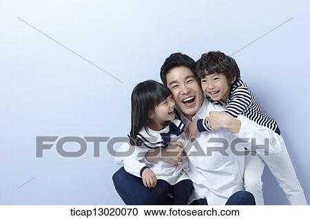 Stock Image - father and kids hugging. Fotosearch