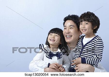 Picture - father hugging kids. Fotosearch