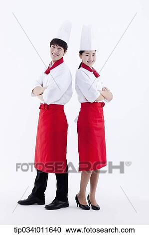Stock Image - female and male cook in red apron posing. Fotosearch
