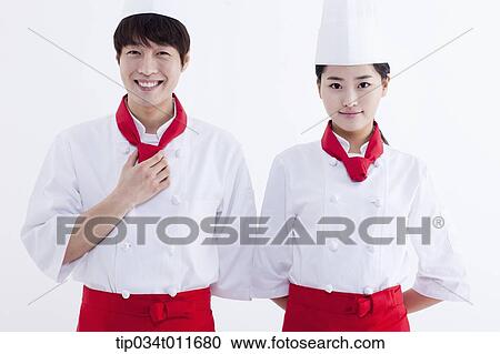 Stock Image - female and male cook in red apron standing together. Fotosearch