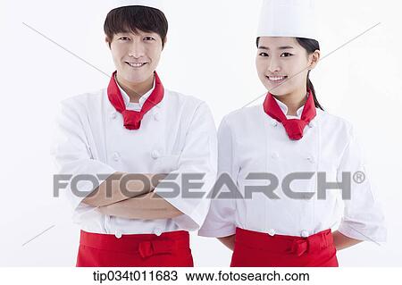 Stock Image - female and male cook in red apron standing together. Fotosearch