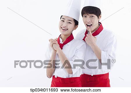 Stock Image - female and male cook in red apron looking happy. Fotosearch