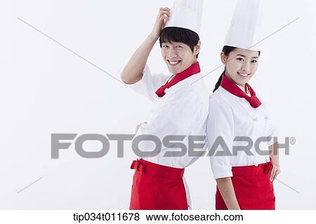 female and male cook in red apron posing while standing back to back View Large Photo Image Stock Photo - female and male cook in red apron posing while standing back to back. Fotosearch