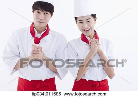 Stock Photography - female and male cook in red apron standing together. Fotosearch