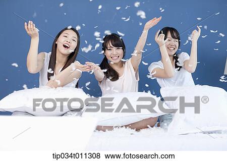 Stock Photo - ladies having a pillow fight. Fotosearch
