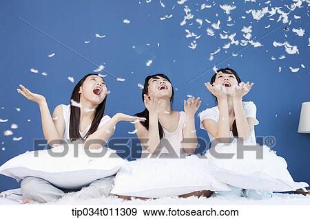 Stock Photo - ladies having a pillow fight. Fotosearch