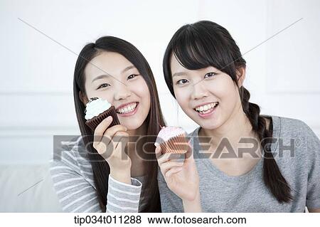 Stock Photo - ladies posing with cupcake. Fotosearch
