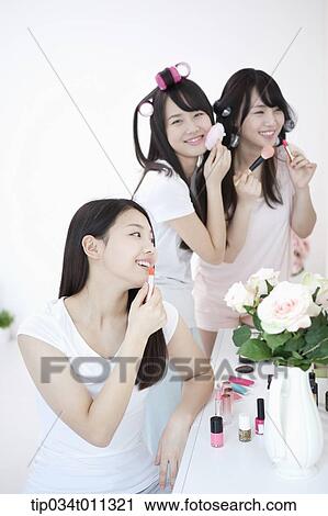 Stock Image - ladies putting make up together. Fotosearch