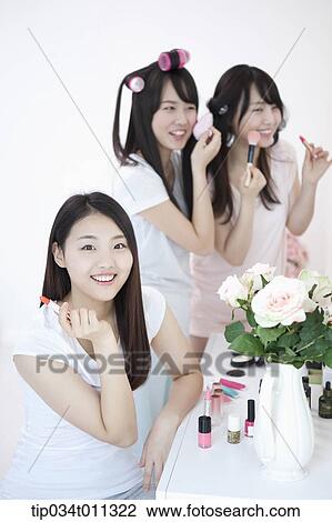 Stock Image - ladies putting make up together. Fotosearch