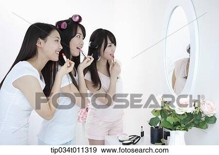 Stock Photo - ladies putting make up together. Fotosearch
