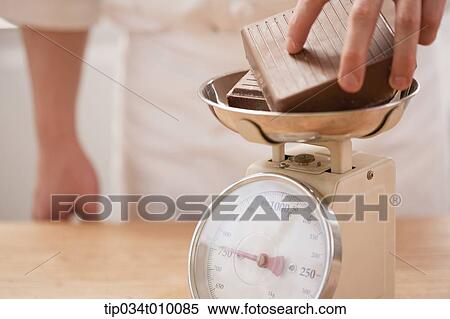 Stock Photography - measuring the weigh of chocolate. Fotosearch