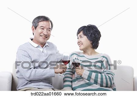 middle aged couple having red wine on a couch View Large Photo Image Stock Image - middle aged couple having red wine on a couch. Fotosearch