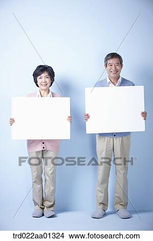 middle aged couple holding blank board View Large Photo Image Picture - middle aged couple holding blank board. Fotosearch