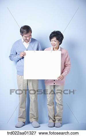 middle aged couple holding blank board View Large Photo Image Stock Photo - middle aged couple holding blank board. Fotosearch