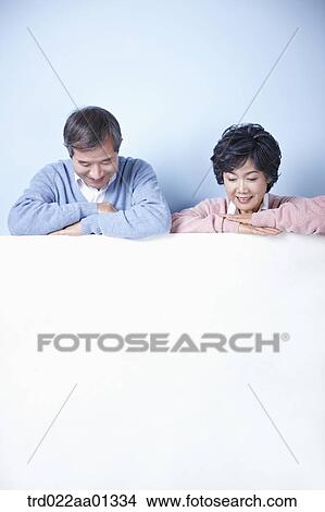 middle aged couple leaning on blank board View Large Photo Image Picture - middle aged couple leaning on blank board. Fotosearch