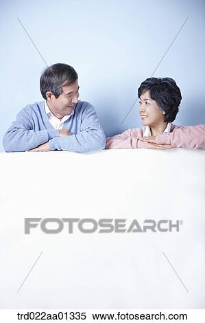 middle aged couple leaning on blank board View Large Photo Image Stock Photography - middle aged couple leaning on blank board. Fotosearch