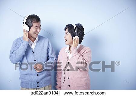 Stock Image - middle aged couple listening to music together. Fotosearch