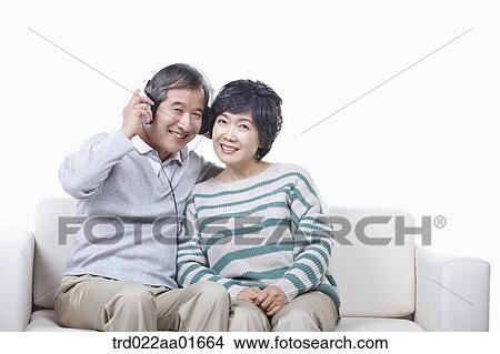 middle aged couple sharing music on a couch View Large Photo Image Picture - middle aged couple sharing music on a couch. Fotosearch