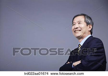 middle aged man in a business suit standing with arms crossed View Large Photo Image Picture - middle aged man in a business suit standing with arms crossed. Fotosearch