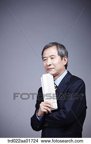 middle aged man in a business suit holding newspaper View Large Photo Image Picture - middle aged man in a business suit holding newspaper. Fotosearch