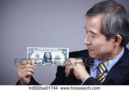middle aged man in a business suit holding a dollar View Large Photo Image Picture - middle aged man in a business suit holding a dollar. Fotosearch