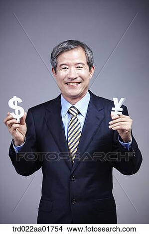 middle aged man in a business suit holding currency blocks View Large Photo Image Picture - middle aged man in a business suit holding currency blocks. Fotosearch