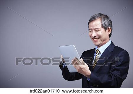 middle aged man in a business suit using tablet PC View Large Photo Image Stock Image - middle aged man in a business suit using tablet PC. Fotosearch