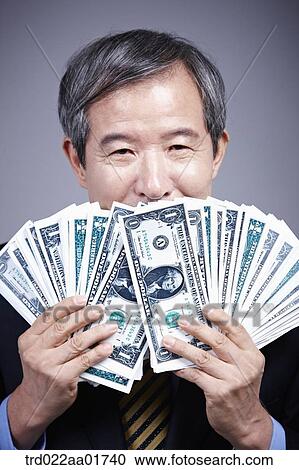 middle aged man in a business suit holding bunch of money View Large Photo Image Stock Image - middle aged man in a business suit holding bunch of money. Fotosearch