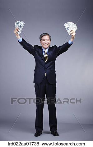 middle aged man in a business suit holding bunch of money View Large Photo Image Stock Photo - middle aged man in a business suit holding bunch of money. Fotosearch